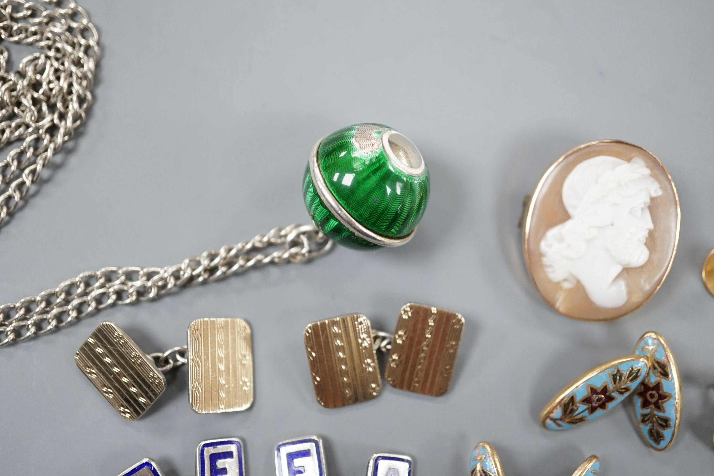 An early 20th century French white and yellow metal, green enamel(a.f.) set pomander, 19mm, on a white metal chain, three French (18ct poincon mark) and baroque pearl set dress studs, gross 3.5 grams, a diamond set 15ct